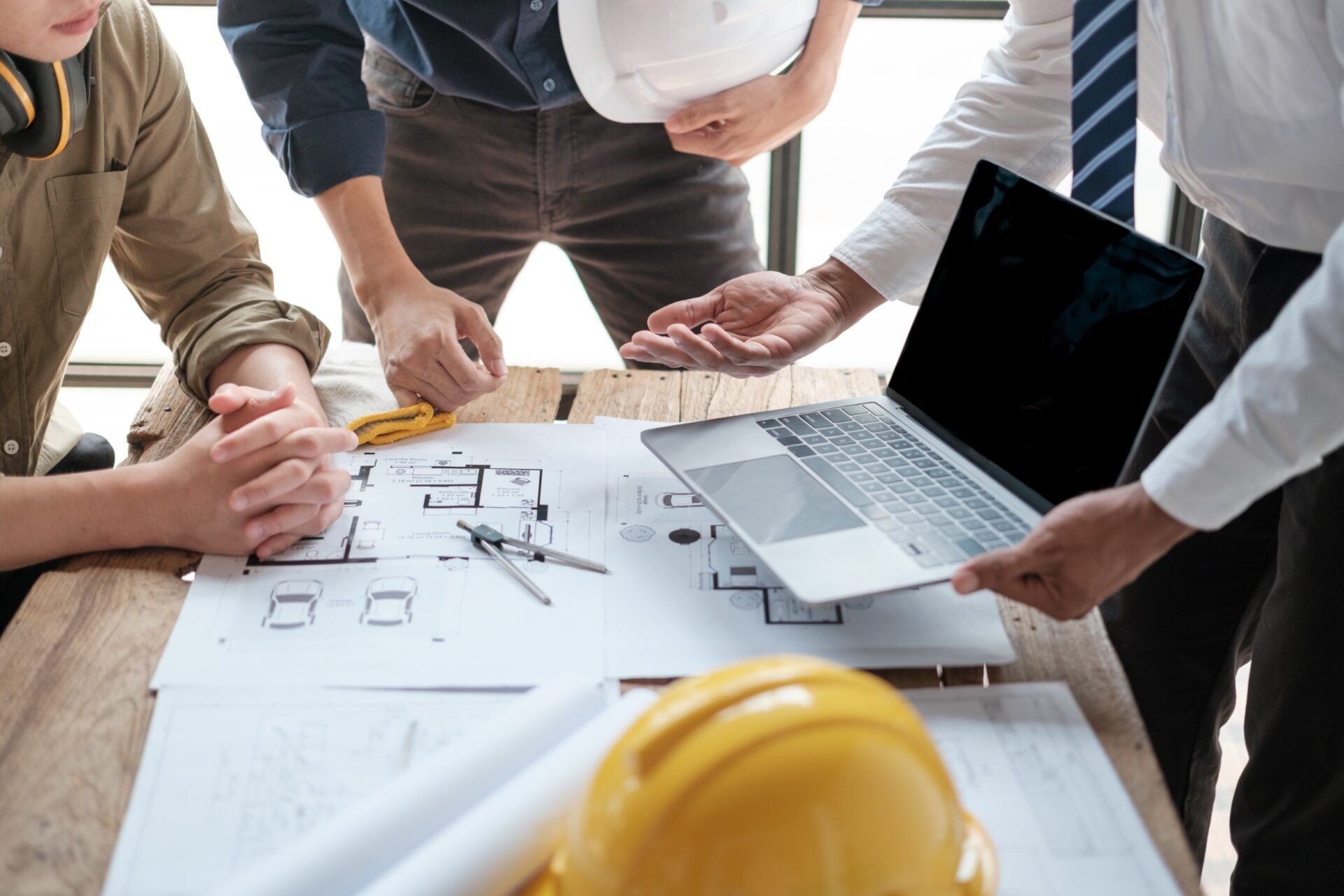 construction consultation on a computer and yellow hard hat